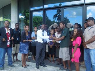 A member of the Young Women's Parliamentary Group Albert Nori and youth representatives of Honiara hand over the signed petition forms
